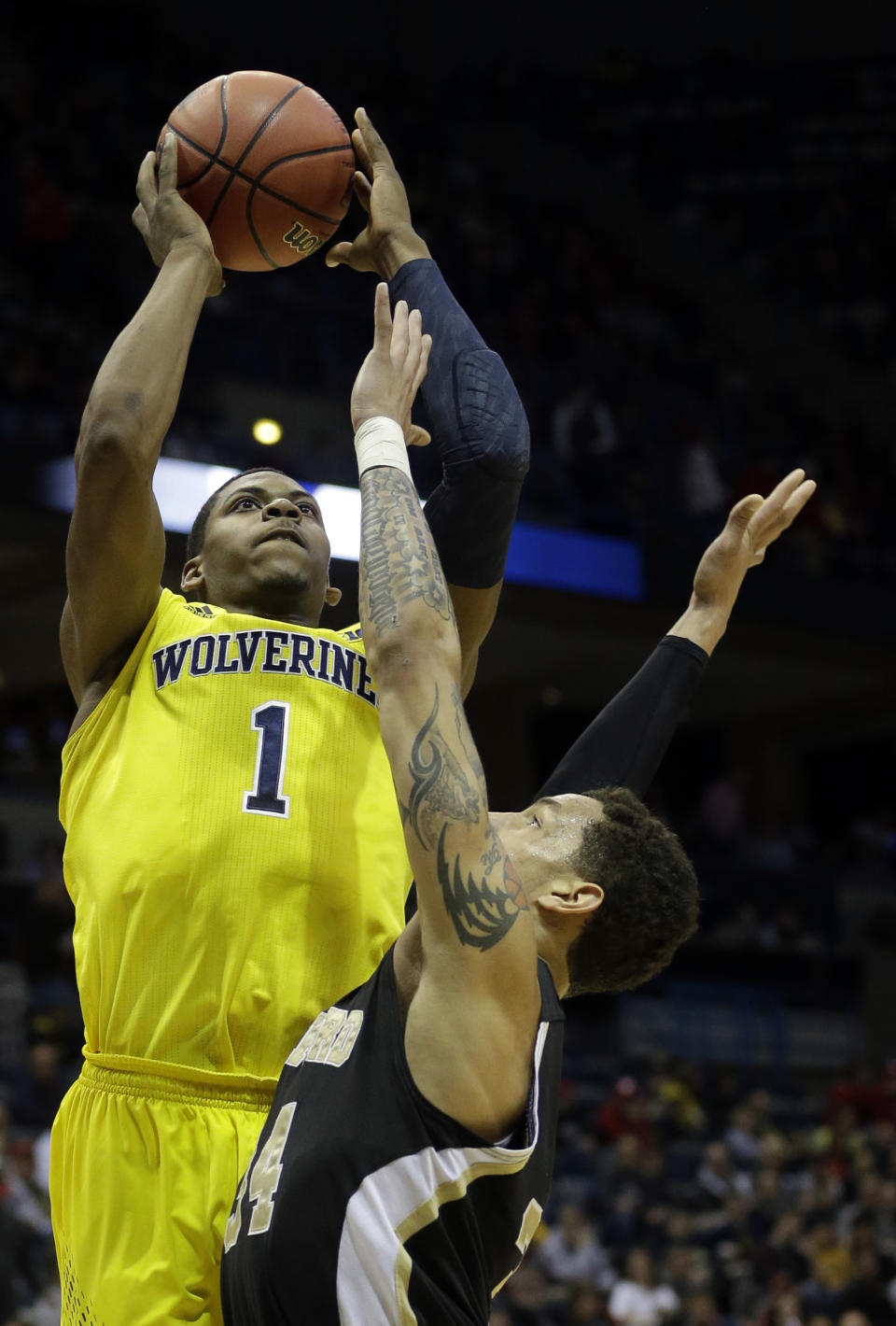 FILE - In this March 20, 2014 file photo, Michigan forward Glenn Robinson III (1) goes up for a shot over Wofford forward Lee Skinner (34) during the first half of a game in Milwaukee. Sophomores Robinson and Nik Stauskas helped the Wolverines win the Big Ten title and reach an NCAA tournament regional final last season. (AP Photo/Morry Gash, File)