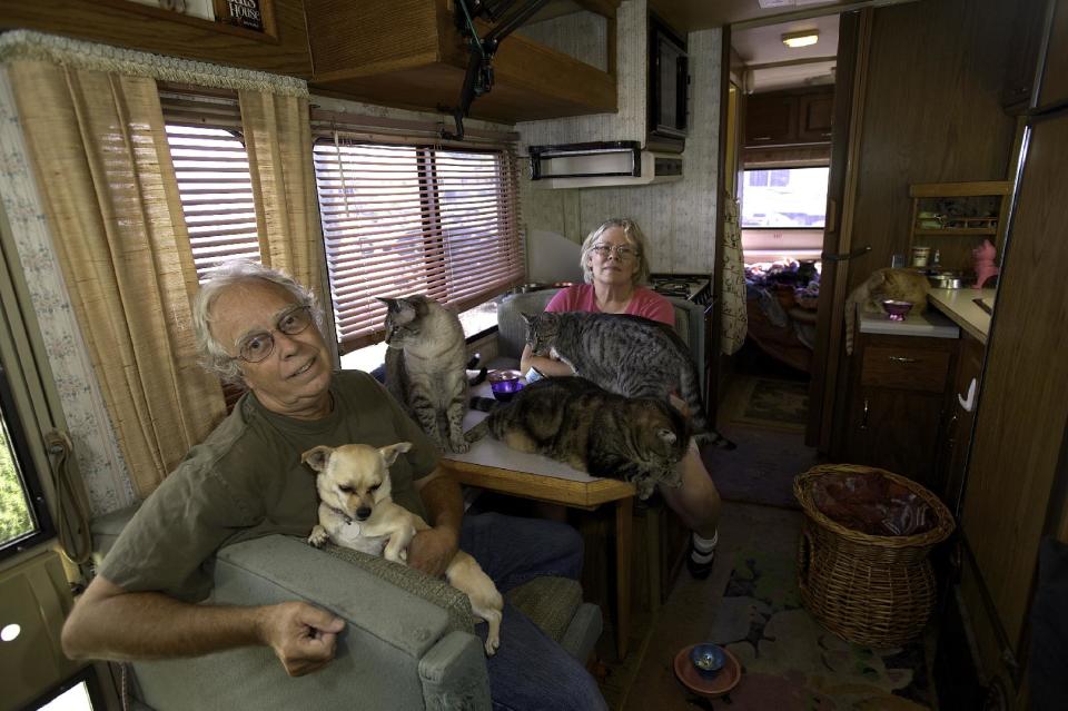 This undated photo released courtesy Bob Walker showing Bob Walker and Frances Mooney with their cats in the motorhome they are living living in San Diego Calif. Walker and Mooney along with eight cats are squeezed into a 30-foot motorhome with the family Chihuahua to wait for their first cross-country trip. Gus, Sam, Dave, Stella, Lili, Eddie, Zander, Willow and Sadie the Chihuahua are biding their time in the motorhome, which is parked in the driveway of the San Diego home. (AP Photo/Courtesy Bob Walker)