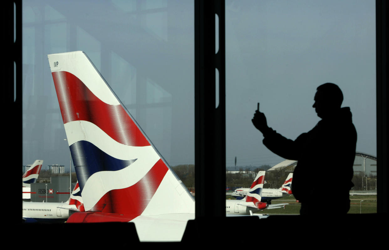 A passenger is seen photographing a British Airways aircraft with his mobile telephone at Heathrow Airport near London in this March 15, 2009 file photo. British Airways slumped to a record loss, nearly doubled its debt pile and cancelled its dividend, adding the tough conditions made it impossible to give any guidance for the current period.  Europe's third-biggest airline by revenue posted operating losses of 220 million pounds ($347.5 million) on May 22, 2009, compared to a profit of 875 million pounds in 2007/08.      REUTERS/Luke MacGregor/    (BRITAIN TRANSPORT BUSINESS TRAVEL)