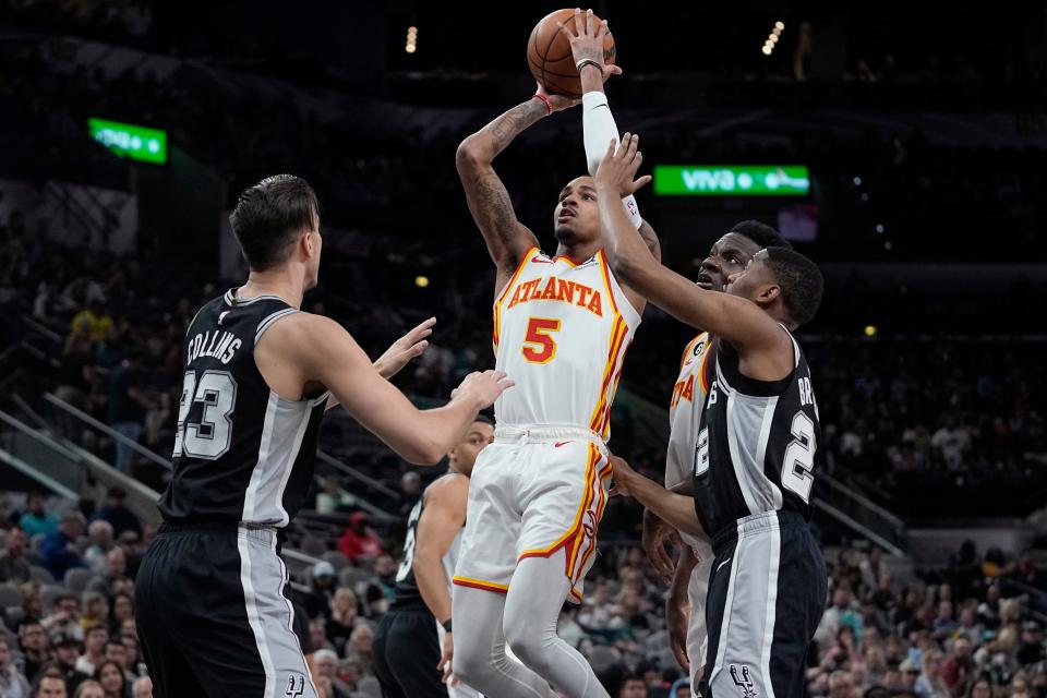 Atlanta Hawks guard Dejounte Murray (5) shoots over San Antonio Spurs forward Zach Collins (23) during the first half of an NBA basketball game in San Antonio, Sunday, March 19, 2023. (AP Photo/Eric Gay)