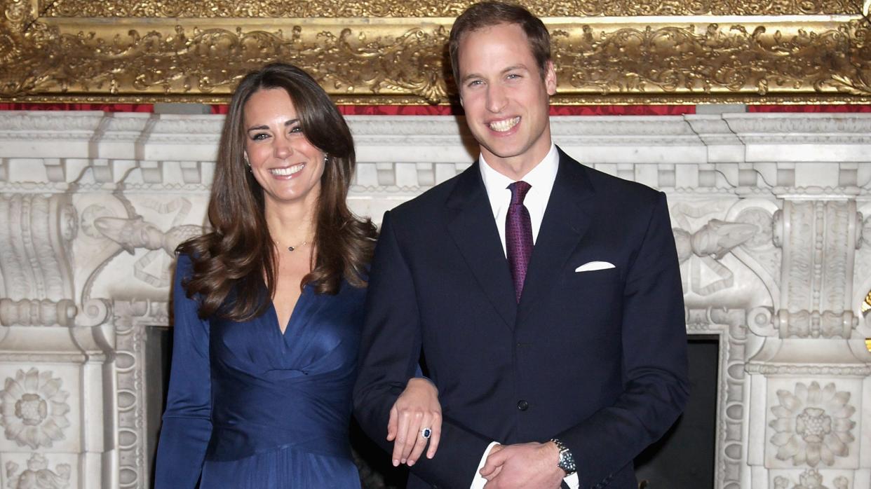 Kate Middleton showing off her engagement ring next to a smiling Prince Wiliam