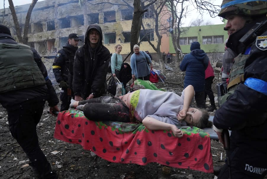烏克蘭孕婦虛弱地躺在擔架上被抬出去，衣服都沾上了血跡。   圖：美聯社／達志影像