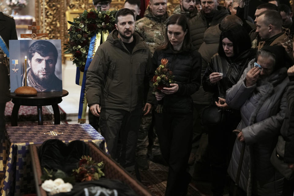 Ukrainian President Volodymyr Zelenskyy and Finland's Prime Minister Sanna Marin attend the funeral of Ukrainian officer Dmytro Kotsiubaylo, code-name "Da Vinci", at the St. Michael's Cathedral, in Kyiv, Ukraine, Friday, March 10, 2023. Kotsiubaylo was killed in a battle near Bakhmut in the Donetsk region three days ago. (AP Photo/Thibault Camus)