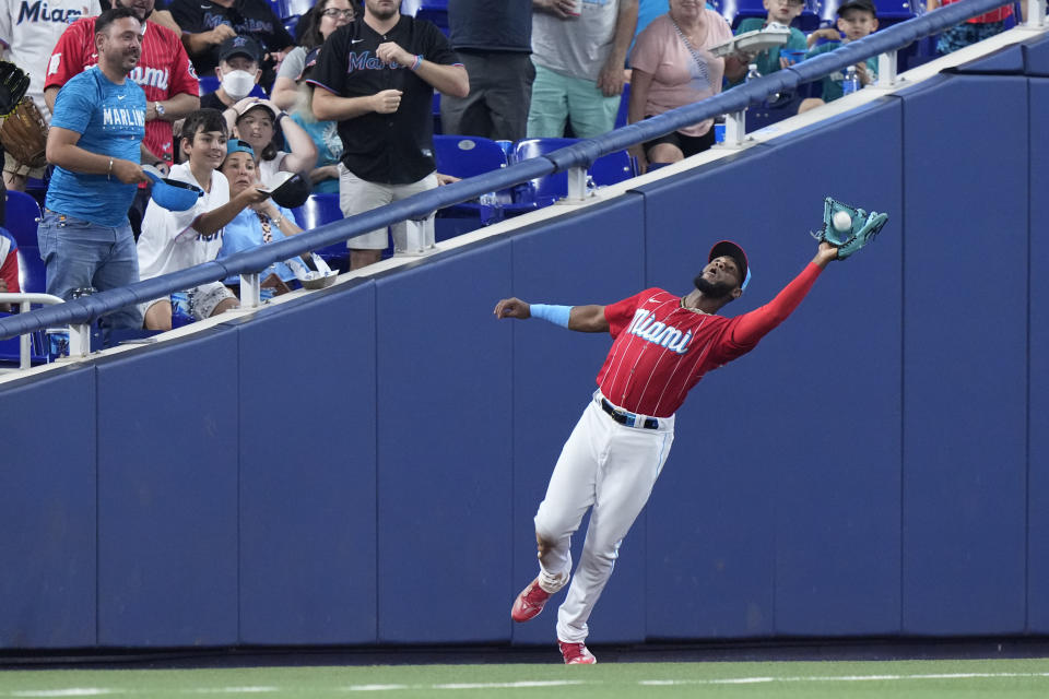 Miami Marlins left fielder Bryan De La Cruz catches a foul ball hit by Cincinnati Reds' Spencer Steer during the fifth inning of a baseball game, Saturday, May 13, 2023, in Miami. (AP Photo/Wilfredo Lee)