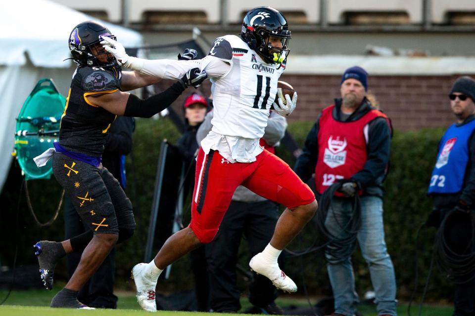 Cincinnati tight end Leonard Taylor scores a touchdown as East Carolina linebacker Aaron Ramseur attempts to stop him in the first half.