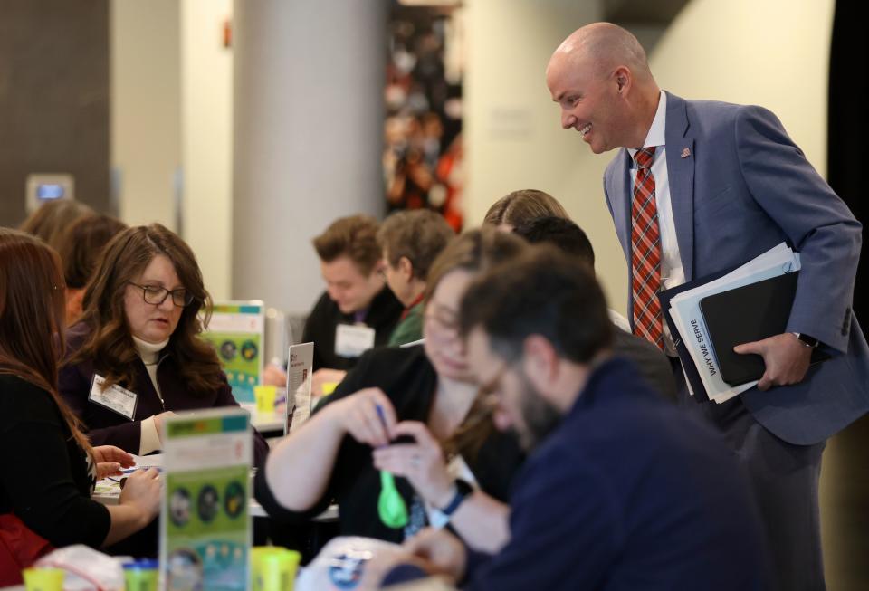 Gov. Spencer Cox checks in on people making Generus mental health and emotional fluency kits as part of a service project during a Why We Serve symposium at the Delta Center in Salt Lake City, on Monday, Jan. 8, 2024. | Kristin Murphy, Deseret News