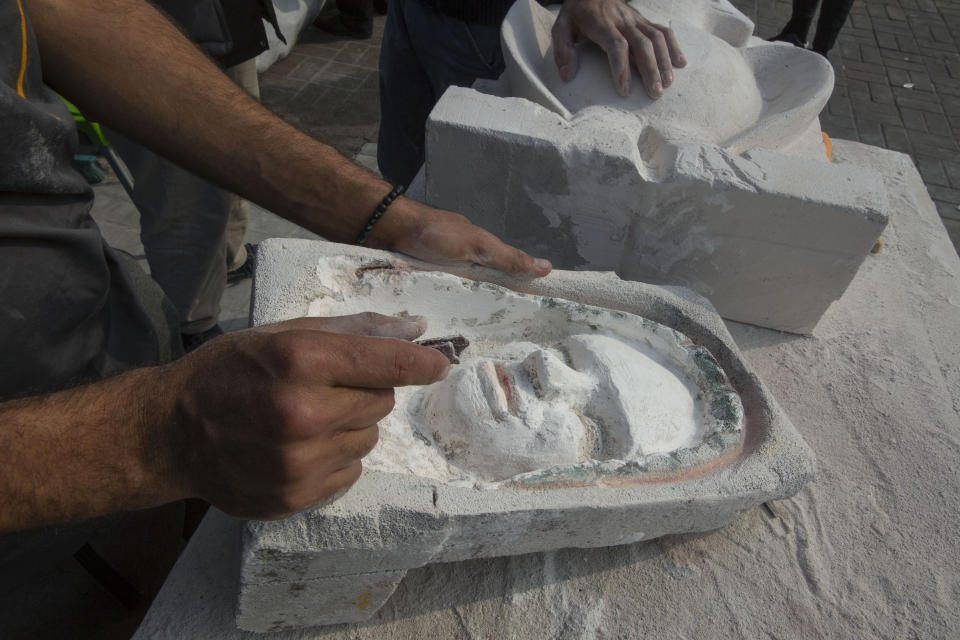 In this Sunday, Dec. 15, 2019, photo, young Iraqi trainees work on sculptures in preparation for their upcoming art exhibition, during the ongoing protests in Tahrir square, Baghdad, Iraq. Tahrir Square has emerged as a focus of the protests, with protesters camped out in dozens of tents. Dozens of people took part in the simple opening of the sculpture exhibition. (AP Photo/Nasser Nasser)