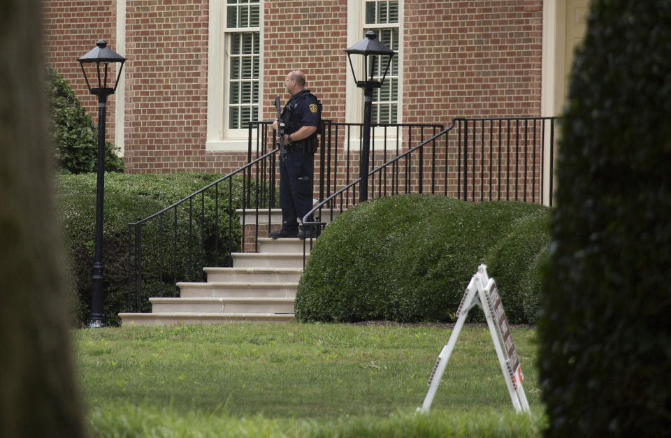 A police officer stands out in front of City Hall next to the building where eleven people were killed during a mass shooting at the Virginia Beach city public works building, May 31, 2019 in Virginia Beach, Va.  (Photo: L. Todd Spencer/The Virginian-Pilot via AP)