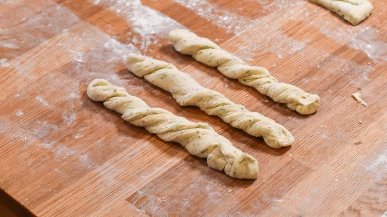 twisted breadstick dough on wood board