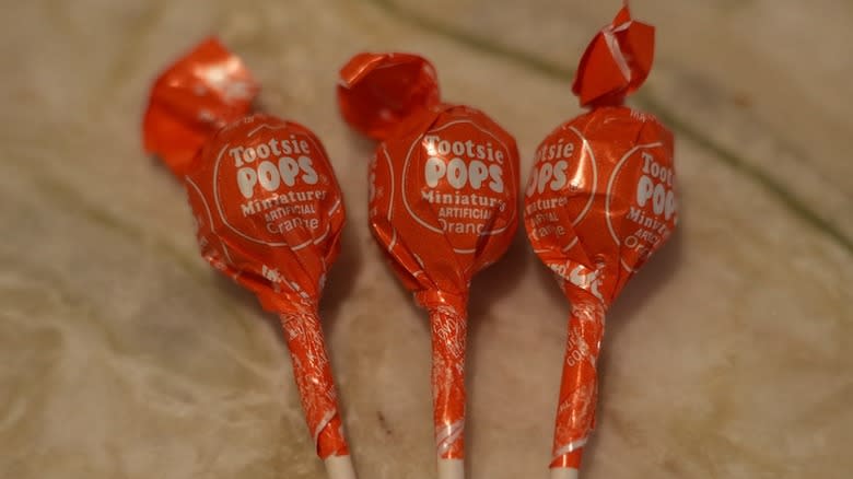 Orange Tootsie Pops in a row