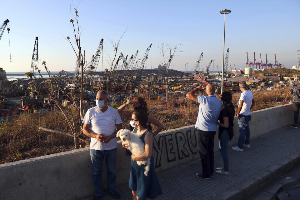 People look at the aftermath of the site of the Aug. 4 explosion that hit the seaport of Beirut, Lebanon, Sunday, Aug. 16, 2020. (AP Photo/Bilal Hussein)