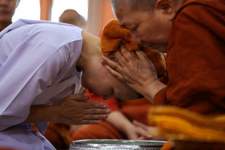 A Thai woman devotee who ended her novice monkhood has her head cleaned by Dhammananda Bhikkhuni (R), 74, abbess at the Songdhammakalyani monastery, Nakhon Pathom province, Thailand, December 14, 2018. REUTERS/Athit Perawongmetha