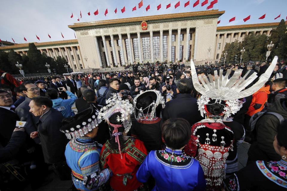 Minority delegates are surrounded by photographers as they arrive at the Great Hall of the People to attend the opening session of the annual National People's Congress in Beijing, Sunday, March 5, 2017. China's top leadership as well as thousands of delegates from around the country are gathered at the Chinese capital for the annual legislature meetings. (AP Photo/Andy Wong)