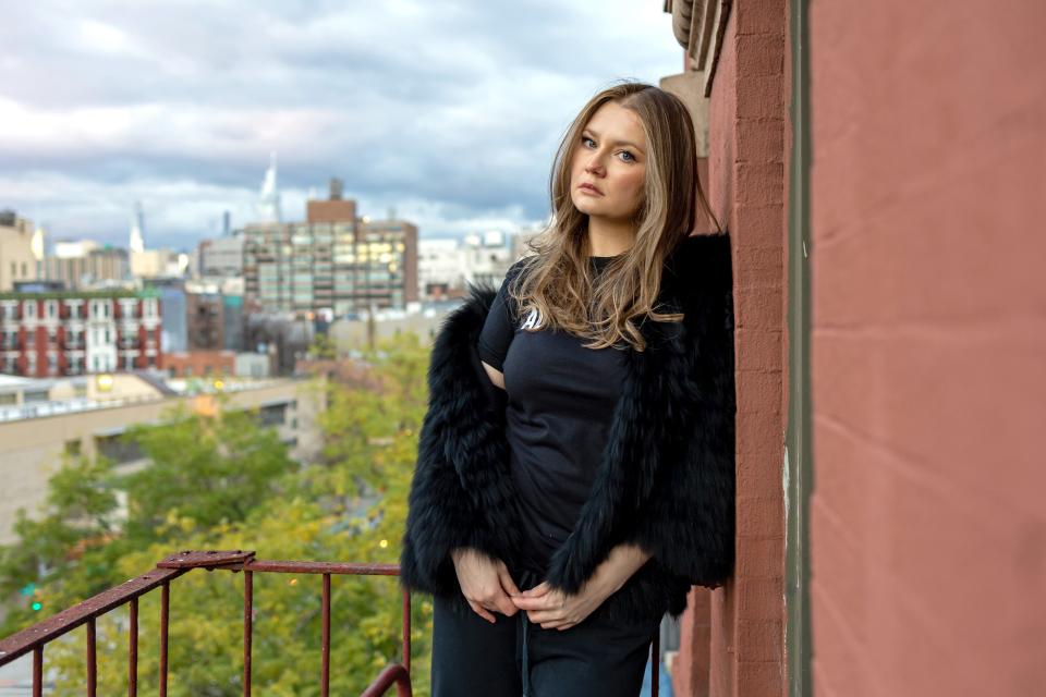 Anna Sorokin/Anna Delvey poses for a photo against a brick wall in New York City