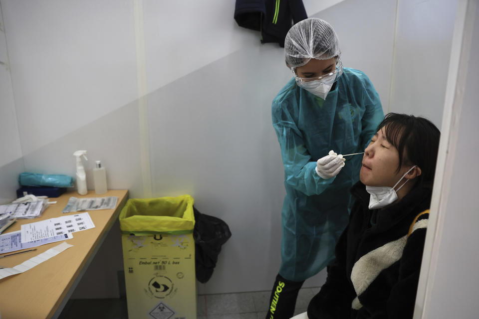 FILE - A passenger arriving from China is tested for COVID-19 at the Roissy Charles de Gaulle airport, north of Paris, Sunday, Jan. 1, 2023. European Union nations are fine-tuning a coordinated response to China's COVID-19 crisis on Wednesday, Jan. 4, 2023 and are zeroing in on travel restrictions that would upset both Beijing and the global airline industry. (AP Photo/Aurelien Morissard, File)