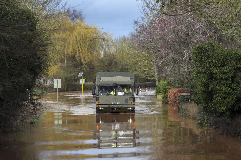 An army vehicle drives through floodwater in the village of Hampton Bishop near Hereford, after the River Lugg burst its banks, Wales, Tuesday Feb. 18, 2020. Britain's Environment Agency issued severe flood warnings Monday, advising of life-threatening danger after Storm Dennis dumped weeks' worth of rain in some places. (Steve Parsons/PA via AP)