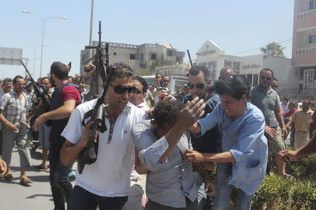 Police officers control the crowd (rear) while surrounding a man (front C) suspected to be involved in opening fire on a beachside hotel in Sousse, Tunisia, as a woman reacts(R), June 26, 2015. REUTERS/Amine Ben Aziza