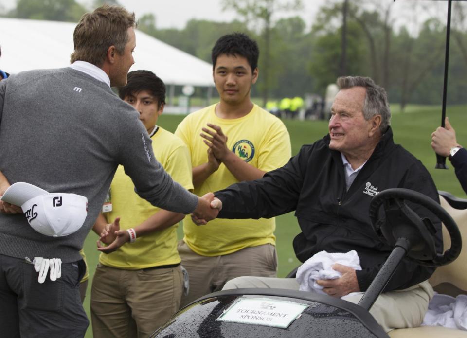 Former President George H. W. Bush congratulates Matt Jones after Jones won the Houston Open golf tournament, Sunday, April 6, 2014, in Humble, Texas. (AP Photo/Patric Schneider)