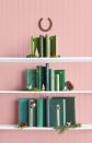 <p>Gather your green books and create a tiered tree by layering the books on three different shelves with pretty accents placed throughout. Get creative with the "tree topper" with any hangable item.</p><p><a class="link " href="https://www.amazon.com/Natural-Decorative-Winter-Holiday-Filler/dp/B075Q98P4D/ref=sr_1_2_sspa?tag=syn-yahoo-20&ascsubtag=%5Bartid%7C10050.g.28872053%5Bsrc%7Cyahoo-us" rel="nofollow noopener" target="_blank" data-ylk="slk:SHOP PINE CONES;elm:context_link;itc:0;sec:content-canvas">SHOP PINE CONES</a></p>