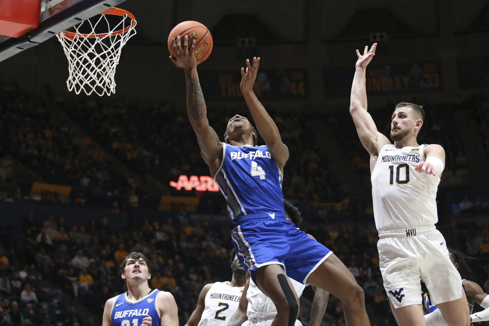 Buffalo guard Armoni Foster (4) shoots while defended by West Virginia guard Erik Stevenson (10) during the first half of an NCAA college basketball game in Morgantown, W.Va., Sunday, Dec. 18, 2022. (AP Photo/Kathleen Batten)