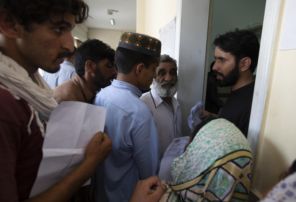 People wait to get their family members suffering from dengue fever, a mosquito-borne disease, admitted to a hospital in Rawalpindi, Pakistan, Tuesday, Sept. 24, 2019. Pakistani health officials are battling an outbreak of dengue fever in the South Asian nation, confirming over 10,000 cases and 20 deaths in recent months. (AP Photo/B.K. Bangash)