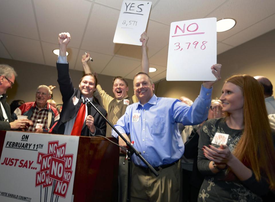 State Sen. Charlie Jansssen of Fremont, third left, Jeremy Jensen, center, and John Wiegert, second right, celebrate in Fremont, Neb., Tuesday, Feb. 11, 2014, after city voters have decided by voting no, to uphold the law designed to bar immigrants from renting homes if they don’t have legal permission to be in the U.S. (AP Photo/Nati Harnik)