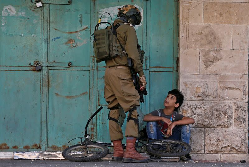 An Israeli soldier detains a Palestinian boy during an anti-Israel protest in Hebron in the Israeli-occupied West Bank