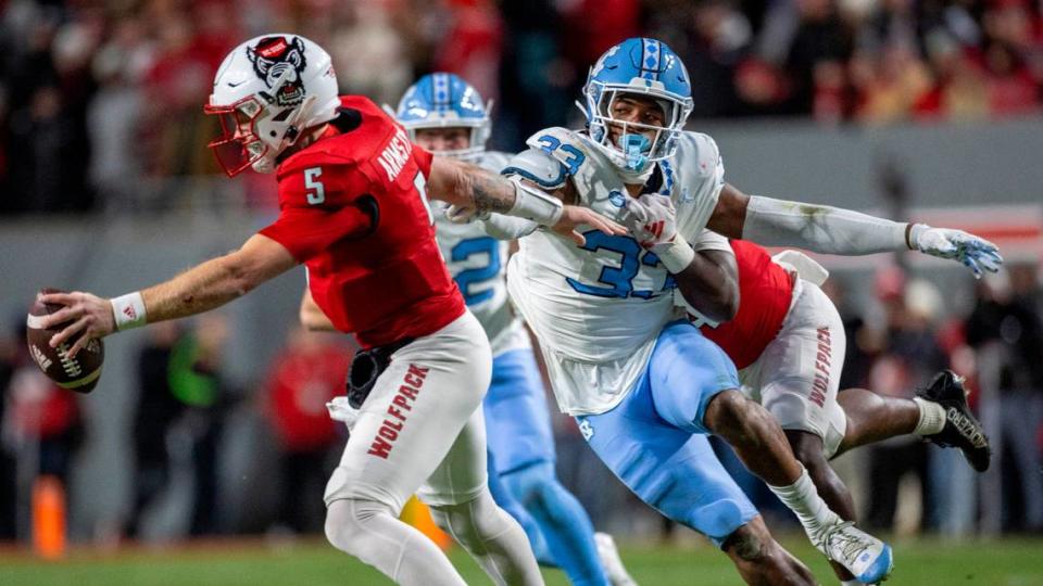 North Carolina’s Cedric Gray (33) pressures N.C. State quarterback Brennan Armstrong (5) in the first quarter on Saturday, November 25, 2023 at Carter-Finley Stadium in Raleigh, N.C.