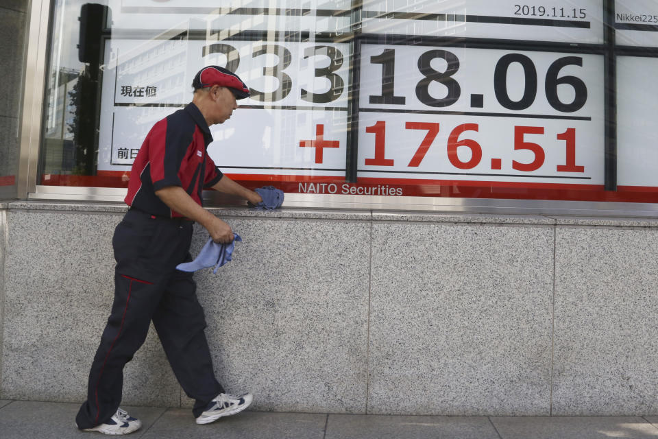 A man cleans up an electronic stock board of a securities firm in Tokyo, Friday, Nov. 15, 2019. Shares are higher in Asia after U.S. officials said China and the U.S. were getting close to an agreement to cool tensions over trade.(AP Photo/Koji Sasahara)