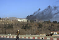 <p>An Afghan security official stand guard as black smoke rises from the Intercontinental Hotel after an attack in Kabul, Afghanistan, Sunday, Jan. 21, 2018. Gunmen stormed the hotel and sett off a 12-hour gun battle with security forces that continued into Sunday morning, as frantic guests tried to escape from fourth and fifth-floor windows. (Photo: Rahmat Gul/AP) </p>