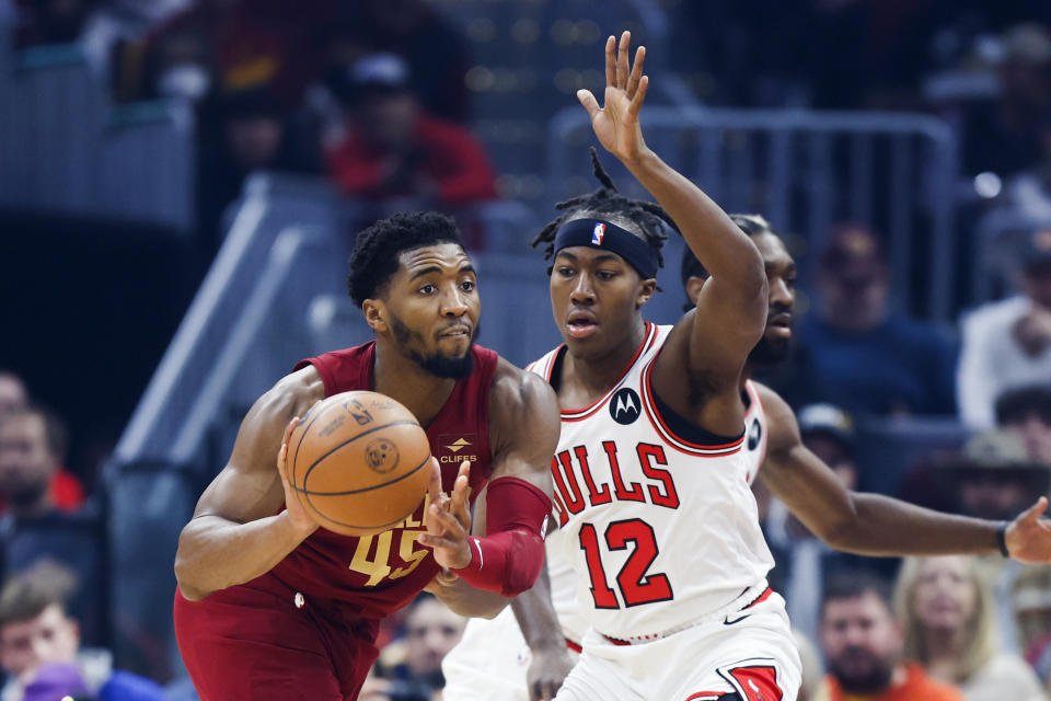 Cleveland Cavaliers guard Donovan Mitchell (45) passes against Chicago Bulls guard Ayo Dosunmu (12) during the first half of an NBA basketball game, Monday, Jan. 2, 2023, in Cleveland. (AP Photo/Ron Schwane)