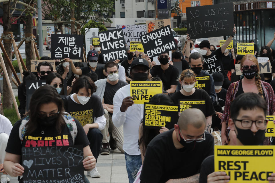 People kneel to protest during a solidarity rally for the death of George Floyd in Seoul, South Korea, Saturday, June 6, 2020. Floyd died after being restrained by Minneapolis police officers on May 25.(AP Photo/Ahn Young-joon)