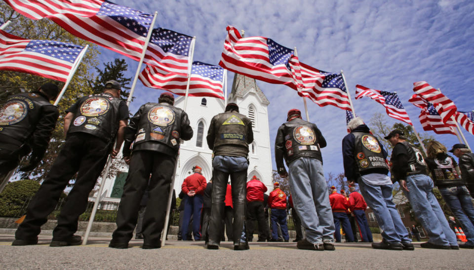 <p>Members of a veterans’ motorcycle club stand holding flags that flap in the breeze outside a memorial service for U.S. Marine Cpl. Christopher Orlando outside St. Paul’s Catholic Church in Hingham, Mass., on April 29, 2016. Orlando and 11 other Marines died on Jan. 14 in a midair collision of two helicopters during a nighttime training mission off Hawaii’s coast.<i> (Charles Krupa/AP)</i></p>