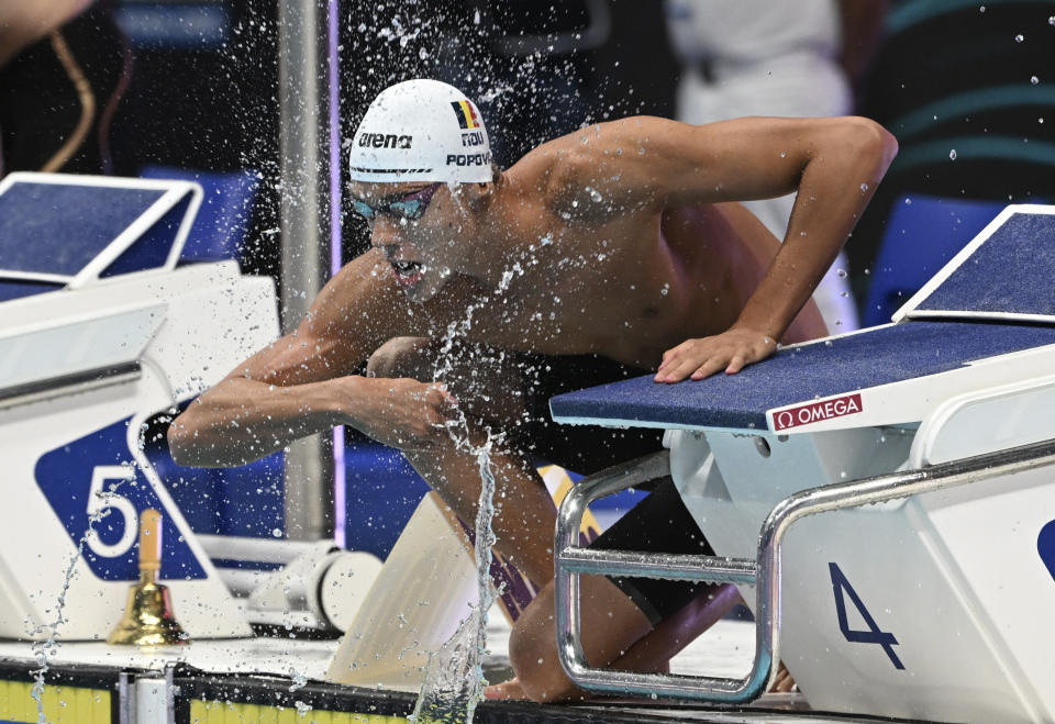 David Popovici of Romania splashes water on his face before the start of the Men 100m Freestyle semifinal at the 19th FINA World Championships in Budapest, Hungary, Tuesday, June 21, 2022. (AP Photo/Anna Szilagyi)