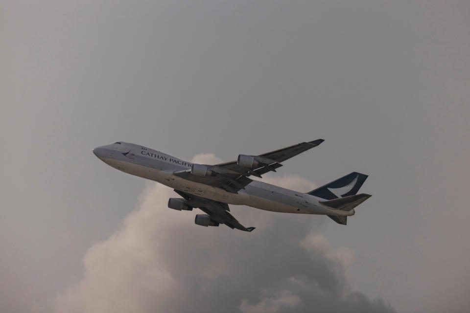 An aircraft operated by Cathay Pacific Airways is seen through glass as it takes off from Hong Kong International Airport in Hong Kong, on Wednesday, March. 8, 2023. Cathay Pacific Airways Ltd. said it was ready to rebuild as Hong Kong opened up to global visitors, despite reporting wider losses in 2022. (AP Photo/Louise Delmotte)