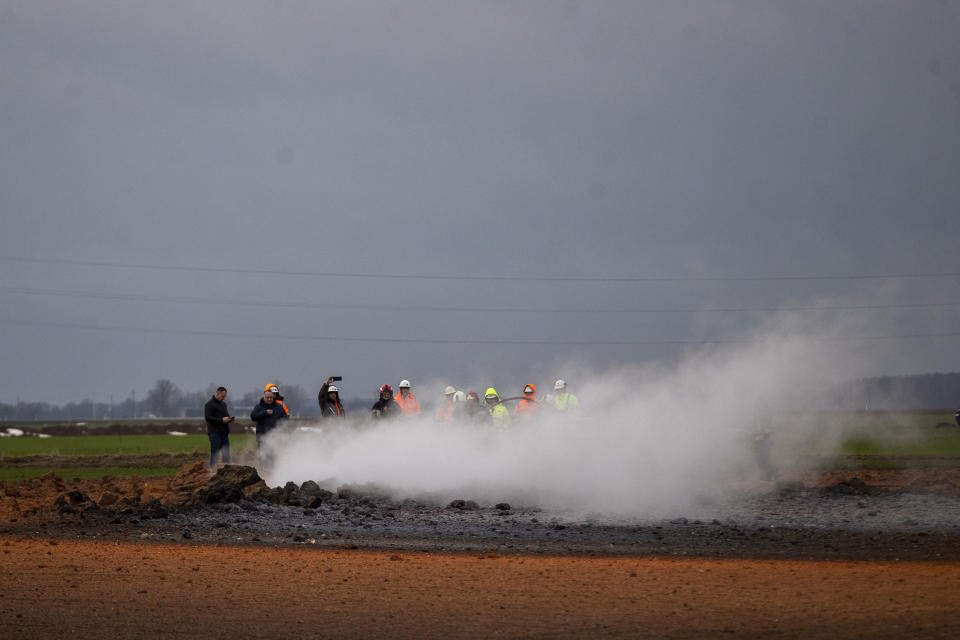 Employees work at the site of the damaged pipeline near Valakeliai village, outside Pasvalys, 175 km (109 miles) north of Vilnius in northern Lithuania on Saturday Jan. 14, 2023. A powerful gas pipeline explosion that prompted the evacuation of a village in northern Lithuania was most likely caused by a technical malfunction, the head of the country's natural gas transmission system said Saturday. The blast Friday evening sent flames 50 meters (about 150 feet) into the sky. (AP Photo/Mindaugas Kulbis)