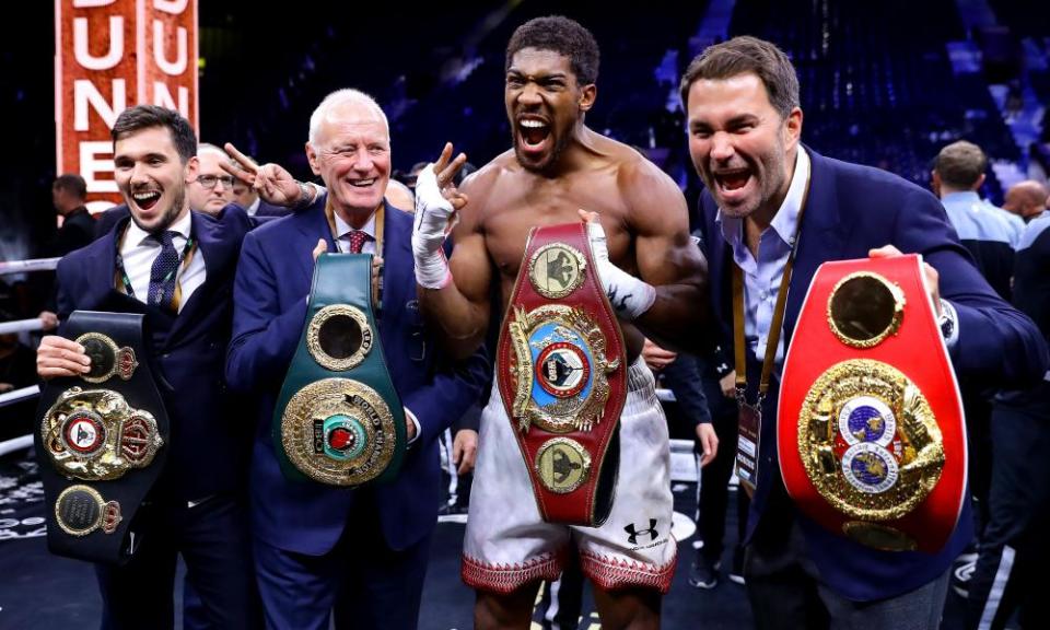 Belting up: Anthony Joshua celebrates regaining his heavyweight titles flanked by Eddie and Barry Hearn, Clash on the Dunes, December 2019, Diriyah, Saudi Arabia.