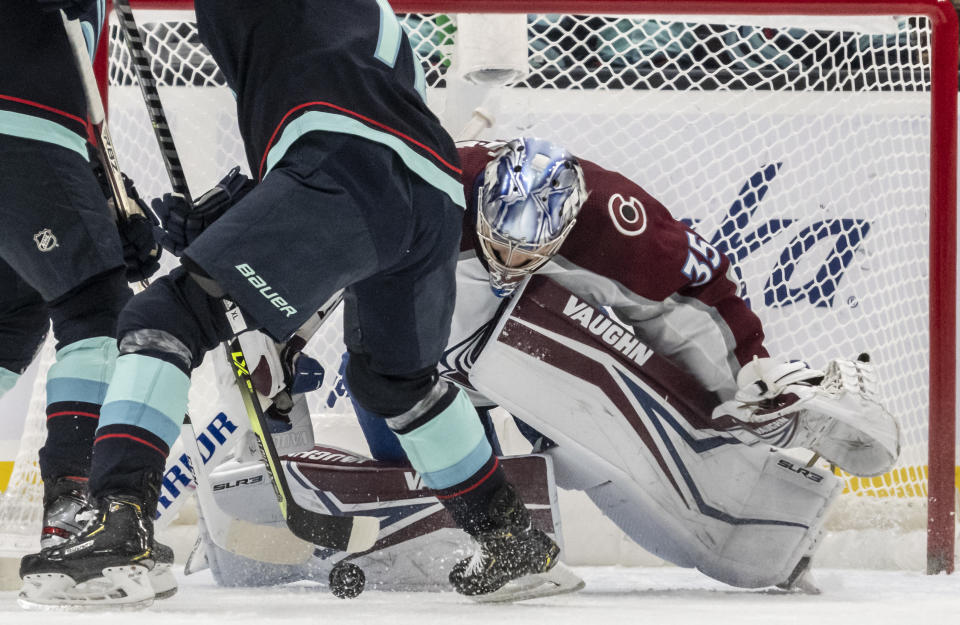 Colorado Avalanche goalkeeper Darcy Kuemper (35) knocks away the puck during the first period of an NHL hockey game against the Seattle Kraken, Friday, Nov. 19, 2021, in Seattle. (AP Photo/Stephen Brashear)