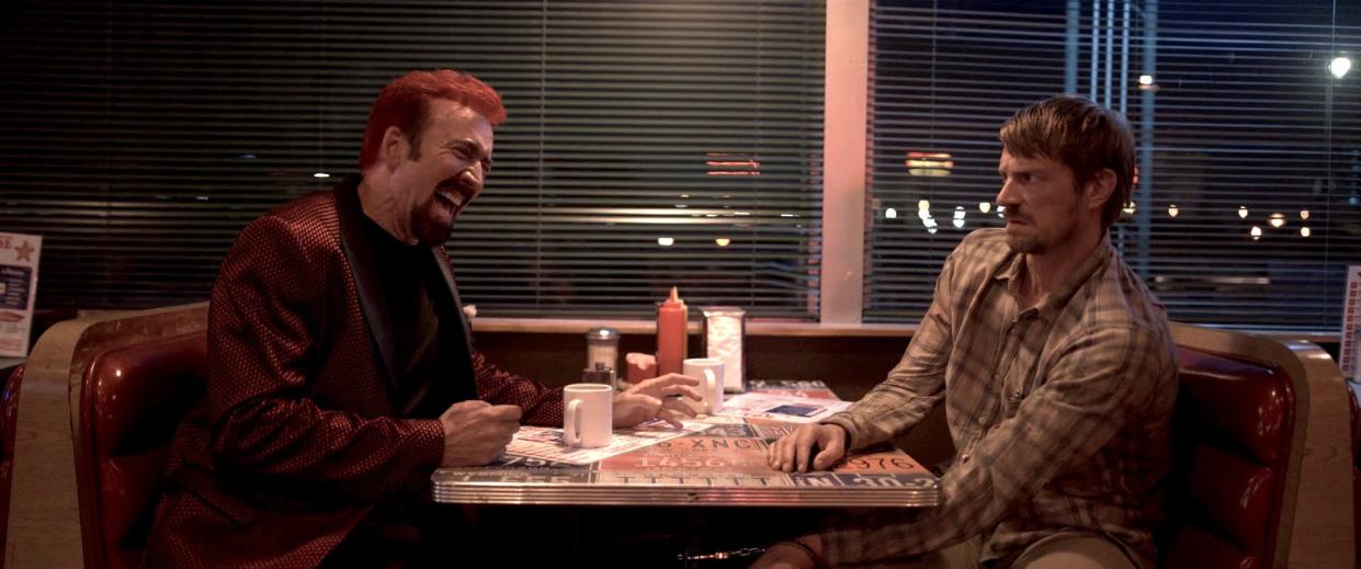 Nicolas Cage (left) plays an unhinged mystery man who forces an expectant father (Joel Kinnaman) to take him on a strange road trip in the psychological thriller "Sympathy for the Devil."