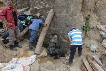 Miners talk to colleagues standing at the entrance of a gold mine blocked by a landslide in San Juan Arriba, on the outskirts of Tegucigalpa July 3, 2014. REUTERS/Jorge Cabrera