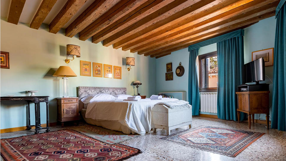 One of the bedrooms with exposed wood-beam ceilings. - Credit: Sotheby's Concierge Auctions