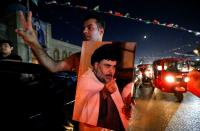 People celebrate on the street after preliminary results were announced, in Sadr City, in Baghdad