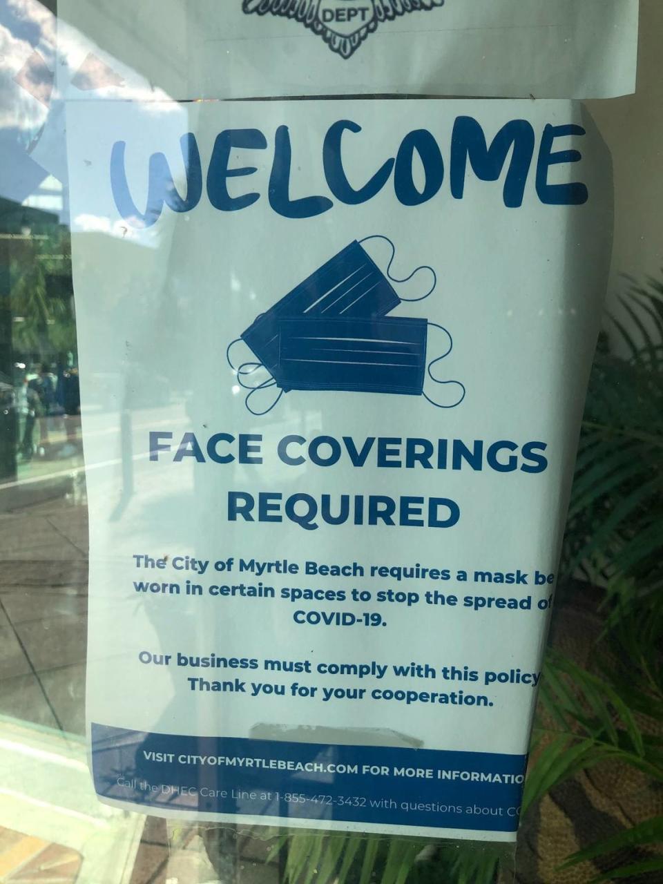 Though the business no longer requires customers to wear masks, a sign remains in the door at the Gay Dolphin Gift Cove on Ocean Boulevard on Thursday.