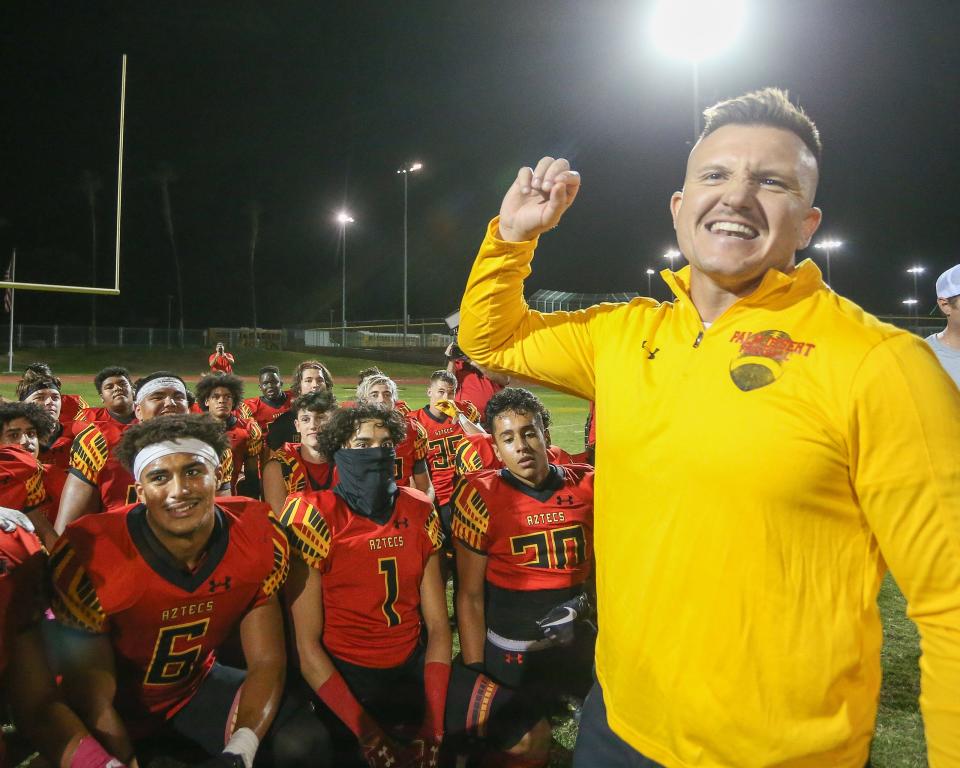 Palm Desert head coach Shane McComb and the Aztecs celebrate their 37-0 win over La Quinta in the Victory Flag game on Oct. 8, 2021.