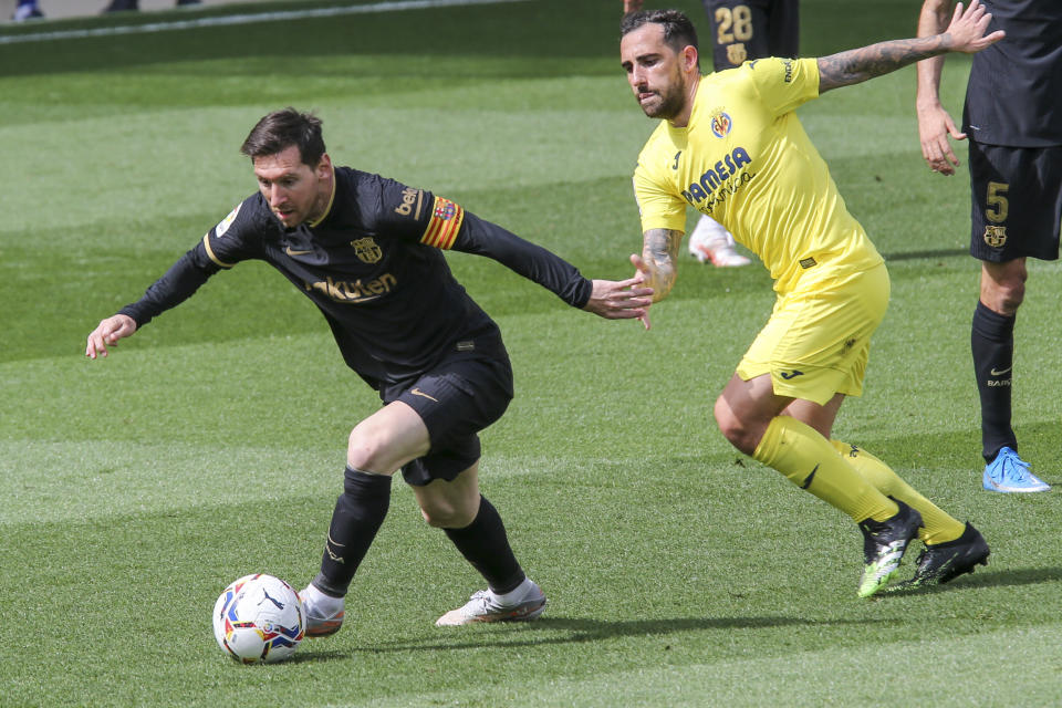 Lionel Messi (izquierda) del Barcelona pugna el balón con Vicente Iborra del Villarreal en el partido por la Liga española, el domingo 25 de abril de 2021. (AP Foto/Alberto Saiz)