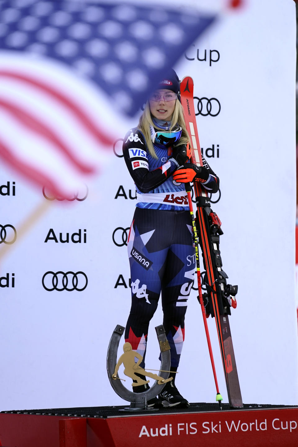 United States' Mikaela Shiffrin listens to the national anthem as she celebrates on the podium after winning an alpine ski, women's World Cup giant slalom race, in Lienz, Austria, Thursday, Dec. 28, 2023. (AP Photo/Giovanni Auletta)