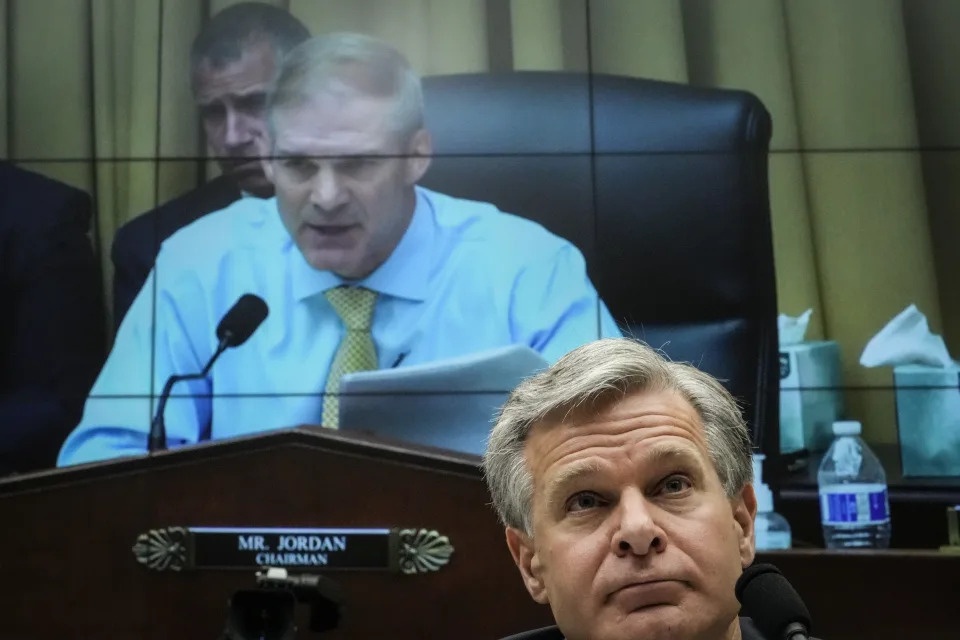 FBI Director Christopher Wray sits in front of a screen showing Rep. Jim Jordan.