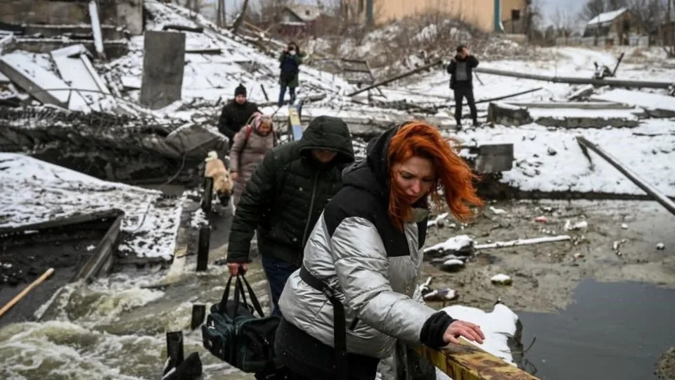 Civiles cruzan un puente destruido en Kiev