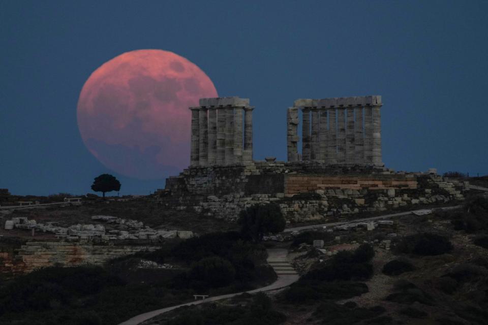 The strawberry full moon rises behind the ancient marble temple of Poseidon at Cape Sounion, about 45 miles south of Athens, on Thursday, June 24, 2021.