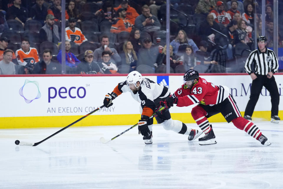 Philadelphia Flyers' Ivan Provorov, left, chases after the puck against Chicago Blackhawks' Colin Blackwell during the third period of an NHL hockey game, Thursday, Jan. 19, 2023, in Philadelphia. (AP Photo/Matt Slocum)